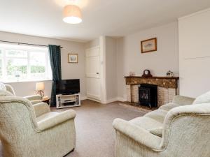 a living room with two chairs and a fireplace at Bilton Farm Cottage No1 in Alnmouth