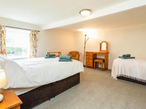 a bedroom with two beds and a window at Bilton Farm Cottage No1 in Alnmouth