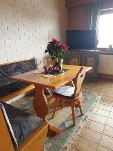 una mesa de madera y sillas en una habitación en Uriges Apartment + Schönblick + mitten im Bayerischen Wald + WLAN kostenfrei, en Schöfweg