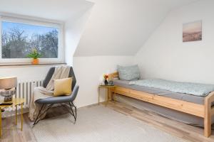 1 dormitorio con 1 cama, 1 silla y 1 ventana en Kiel Elmschenhagen Ostufer, en Kiel
