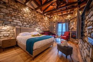 1 dormitorio con cama y pared de piedra en Mple Feggari, en Mouresi