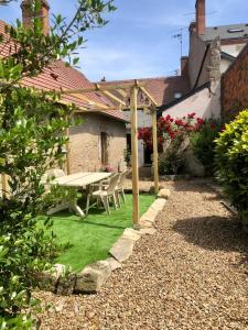 a garden with a picnic table and green grass at Les Mariniers in Châteauneuf-sur-Loire