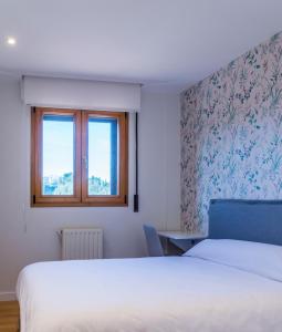 a bedroom with a bed and a window at PAKELEKU in San Sebastián