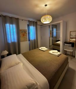 a bedroom with two beds and a chandelier at Blue Salt in Kalo Livadi