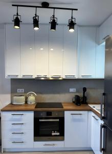 a kitchen with white cabinets and a black appliance at Blue Salt in Kalo Livadi