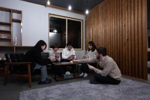 un grupo de personas en una habitación jugando un videojuego en ロッヂモントゼー, en Yuzawa