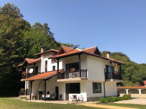 a large white house with a balcony at Wildwood Villa in Apriltsi