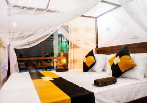 a bedroom with a bed with yellow and black pillows at Kurundu Wadiya (Cinnamon Retreat) in Hikkaduwa