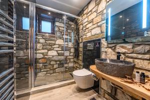 La salle de bains en pierre est pourvue d'un lavabo et d'une douche. dans l'établissement Mple Feggari, à Mouresi