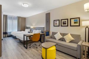 um quarto de hotel com uma cama e um sofá em Comfort Inn & Suites em Sayre