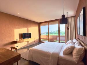 1 dormitorio con 1 cama grande y TV en New! Gorgeous 3BD Villa close to Canggu, en Tanah Lot