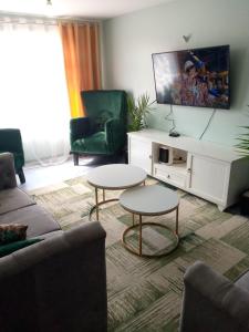 a living room with a couch and two tables at Lux Suites Milimani Business Apartments Nakuru in Nakuru