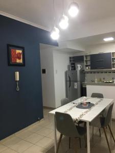 a kitchen with a white table and chairs and a refrigerator at Departamento Boulevard con cochera in Santa Fe