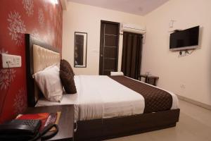 新德里的住宿－Hotel Tourist Palace Near Delhi Airport，一间卧室配有一张床和一张带电话的书桌