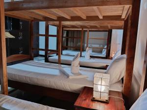 Un grupo de 4 camas en una habitación en Forest Bay Inn El Nido, en El Nido