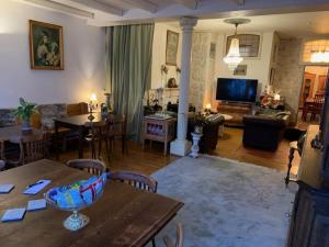 a living room with a table and a living room with a couch at B&B Petit Chateau - Rust en Charme Nabij Gent, Brugge en de Zeeuwse kust in Biervliet