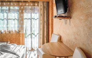 マイヤーホーフェンにあるBeautiful Home In Mayrhofen With 3 Bedroomsのテーブルと壁掛けテレビ付きの小さな部屋