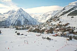 a group of people skiing down a snow covered mountain at Résidence Provençal by Leavetown Vacations in Les Deux Alpes