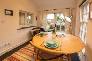 a dining room with a table and a bottle of wine at Fold Cottage, Outgate near Ambleside in Hawkshead