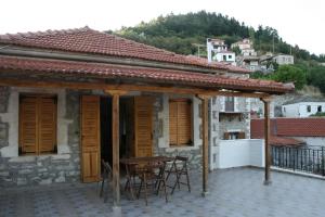 een huis met een tafel en stoelen op een patio bij Maleatis Apollo Guesthouse in Kosmás