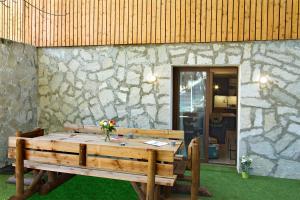 a wooden table in front of a stone wall at Résidence Provençal by Leavetown Vacations in Les Deux Alpes