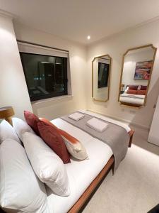 una camera da letto con un grande letto bianco con due cuscini di NEW Spacious 2 bedroom Apartment with Balcony a Londra