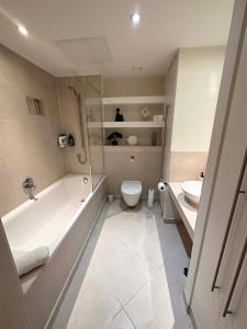 uma casa de banho com uma banheira, um WC e um lavatório. em NEW Spacious 2 bedroom Apartment with Balcony em Londres