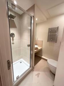uma casa de banho com um chuveiro e um WC. em NEW Spacious 2 bedroom Apartment with Balcony em Londres