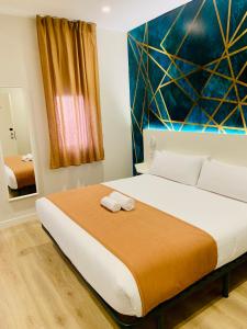 een slaapkamer met een bed met twee handdoeken erop bij Hostal Abadia Madrid in Madrid
