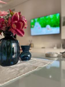 a blue vase with flowers sitting on a table at Schöne, ruhige neuwertige 127qm Ferienwohnung in Sidi Daoud