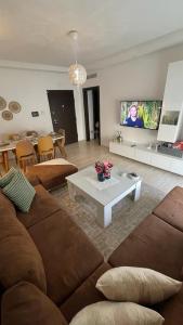 a living room with a couch and a coffee table at Schöne, ruhige neuwertige 127qm Ferienwohnung in Sidi Daoud