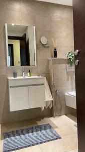 W łazience znajduje się umywalka, lustro i toaleta. w obiekcie Schöne, ruhige neuwertige 127qm Ferienwohnung w mieście Sidi Daoud