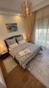 a bedroom with a large bed and a chandelier at Schöne, ruhige neuwertige 127qm Ferienwohnung in Sidi Daoud