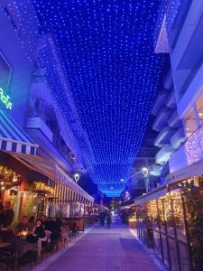 una calle con luces azules colgando de un edificio en 1910 Lifestyle Hotel en Volos