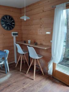 una stanza con tavolo, sedie e orologio di Le petit chalet a Chanas