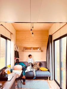 two people sitting on a couch in a tiny house at Tiny House nature proche Montargis - 1h de Paris ! 