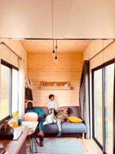 two people sitting on a couch in a tiny house at Tiny House nature proche Montargis - 1h de Paris ! in Girolles