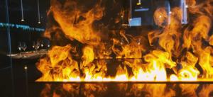 a fire is burning in a room with flames at Brut Wine Hotel in Zarasai