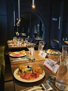 - une table avec des assiettes de nourriture et des verres à vin dans l'établissement Brut Wine Hotel, à Zarasai