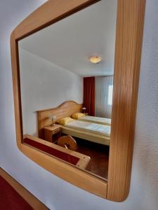 a reflection of a bedroom with a bed in a mirror at Hotel-Aparthotel San Bernardino in San Bernardino