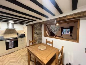 - une cuisine avec une table en bois dans une chambre dans l'établissement Scenic 2 bedroom Cottage, à Hill Top