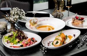 a table with plates of food on a table at Cat Ba Paradise Pool & Sky Bar in Cat Ba