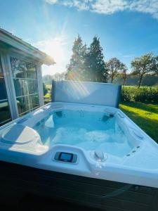 a jacuzzi tub in a yard with a window at Secret Wellness Lonneker in Enschede