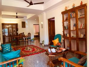 sala de estar con sillas azules y mesa en Surendram Villa en Varkala