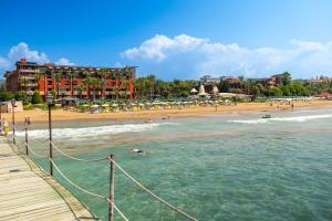 ein Strand mit Hotel und Menschen im Wasser in der Unterkunft AQI Pegasos Club in Avsallar