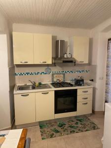 cocina con armarios blancos y fogones en Casa Baiettini 9 en Intra