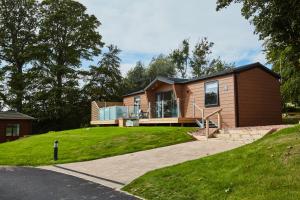 a house on a hill with a driveway at Letham Feus Lodge and Caravan Park in Fife