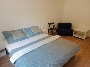 una camera da letto con un letto con cuscini blu e una sedia di Promenáda 16 a Trutnov