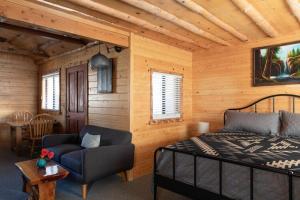 ein Schlafzimmer mit einem Bett und einem Stuhl in einem Zimmer in der Unterkunft 2401 - Oak Knoll Studio with Jacuzzi #2 cabin in Big Bear Lake