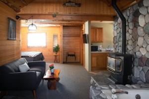 sala de estar con sofá y chimenea de piedra en 2401 - Oak Knoll Studio with Jacuzzi #2 cabin en Big Bear Lake